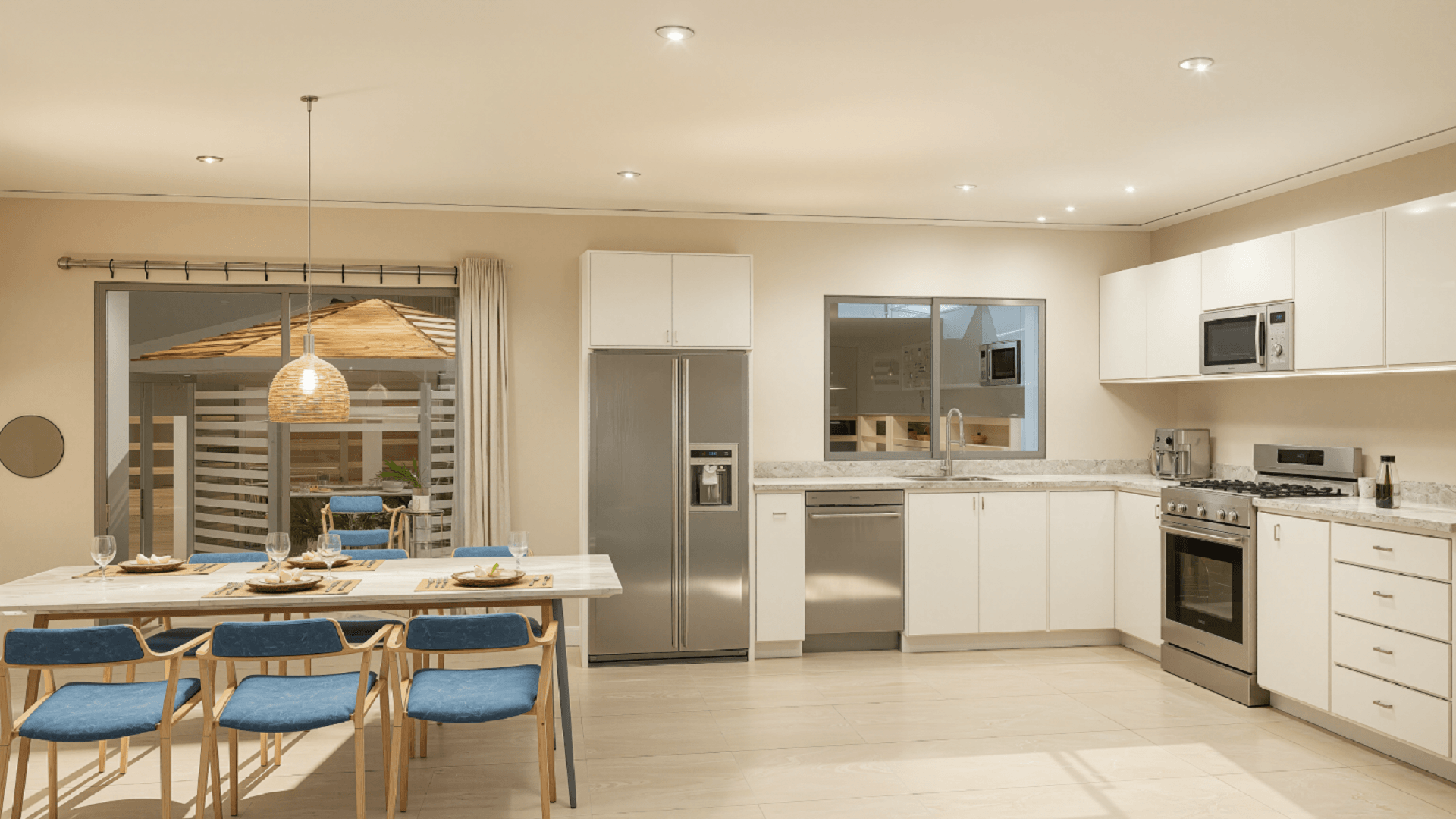 Modern kitchen and dining area inside Summerside III townhouse with stainless steel appliances and white cabinets