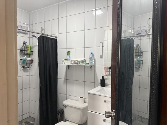Bathroom with shower, vanity, and tiled finishes in the Alto Vista 26 W apartment.