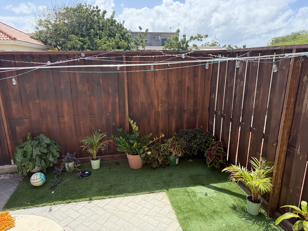 Outdoor garden area with decorative plants beside the apartment in Alto Vista, Aruba.