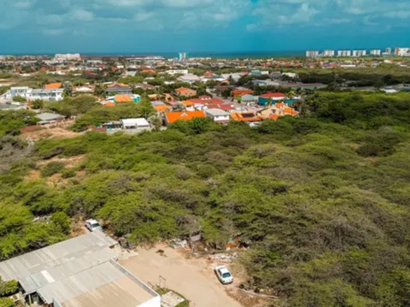 Aerial view of development land in Bubali, Noord, Aruba, with surrounding residential areas and a distant coastal skyline.