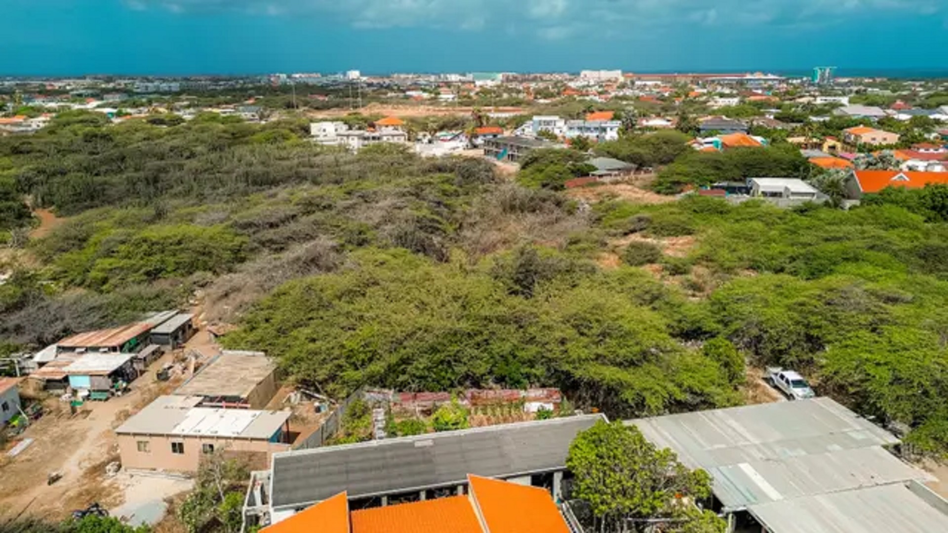 Elevated aerial view of development land in Bubali, Noord, Aruba, with residential communities and vegetation extending across the landscape.