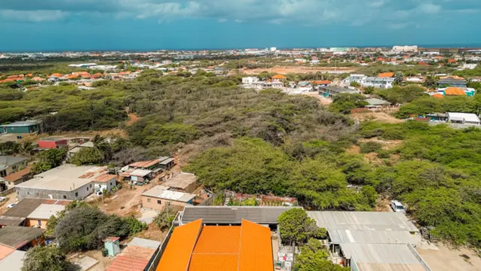 Aerial perspective of the development land for sale in Bubali, Noord, Aruba, surrounded by residential properties and mature vegetation.