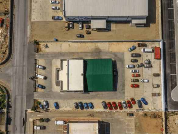 Aerial top-down view of the Commercial Office Space for Rent at Schotlandstraat 77-A Aruba showing the office building, paved parking areas, and surrounding commercial properties.