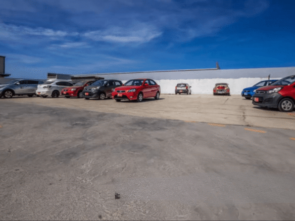 Parking area at the Commercial Office Space for Rent at Schotlandstraat 77-A Aruba with multiple vehicles parked on the paved lot.