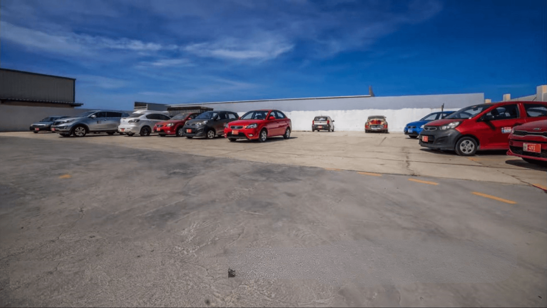 Parking area at the Commercial Office Space for Rent at Schotlandstraat 77-A Aruba with multiple vehicles parked on the paved lot.