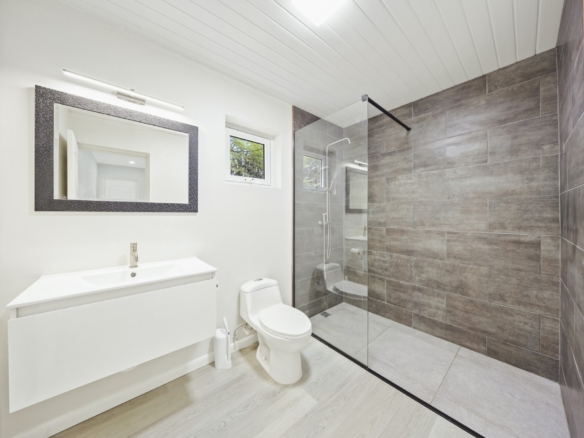 Modern bathroom with floating vanity and glass-enclosed walk-in shower at Pos Abao 10 F villa in Noord, Aruba.
