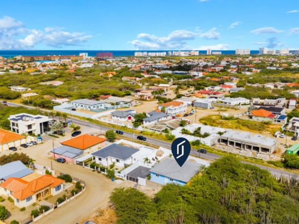 Wide exterior view of Pos Abao 10 F villa showing the paved driveway and front elevation in Noord, Aruba.