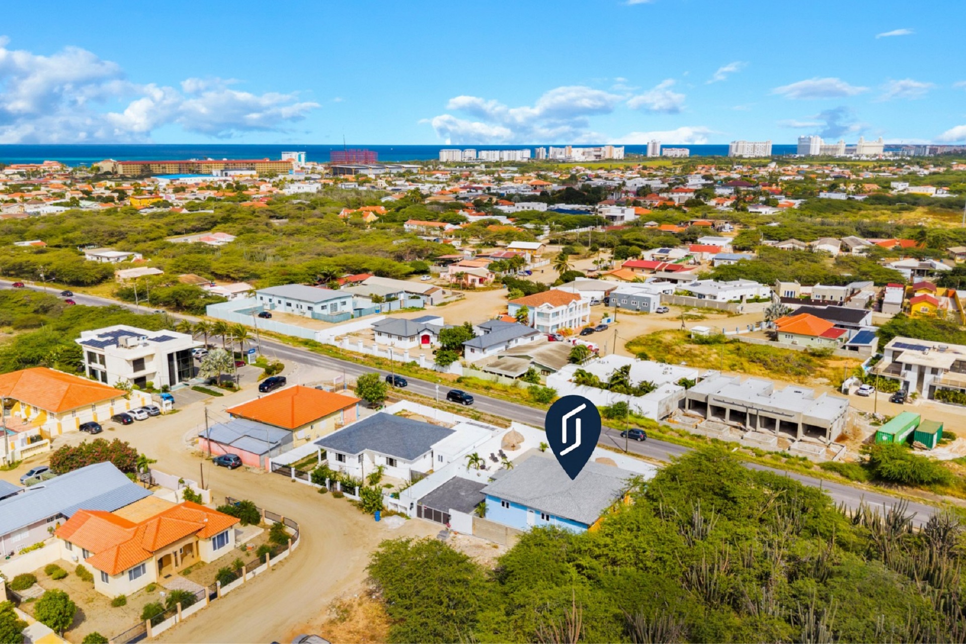 Wide exterior view of Pos Abao 10 F villa showing the paved driveway and front elevation in Noord, Aruba.