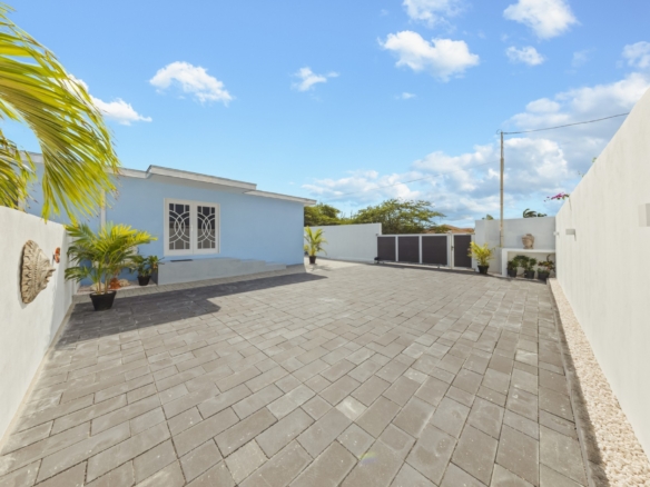 Large paved driveway and gated entrance at Pos Abao 10 F villa in Noord, Aruba.