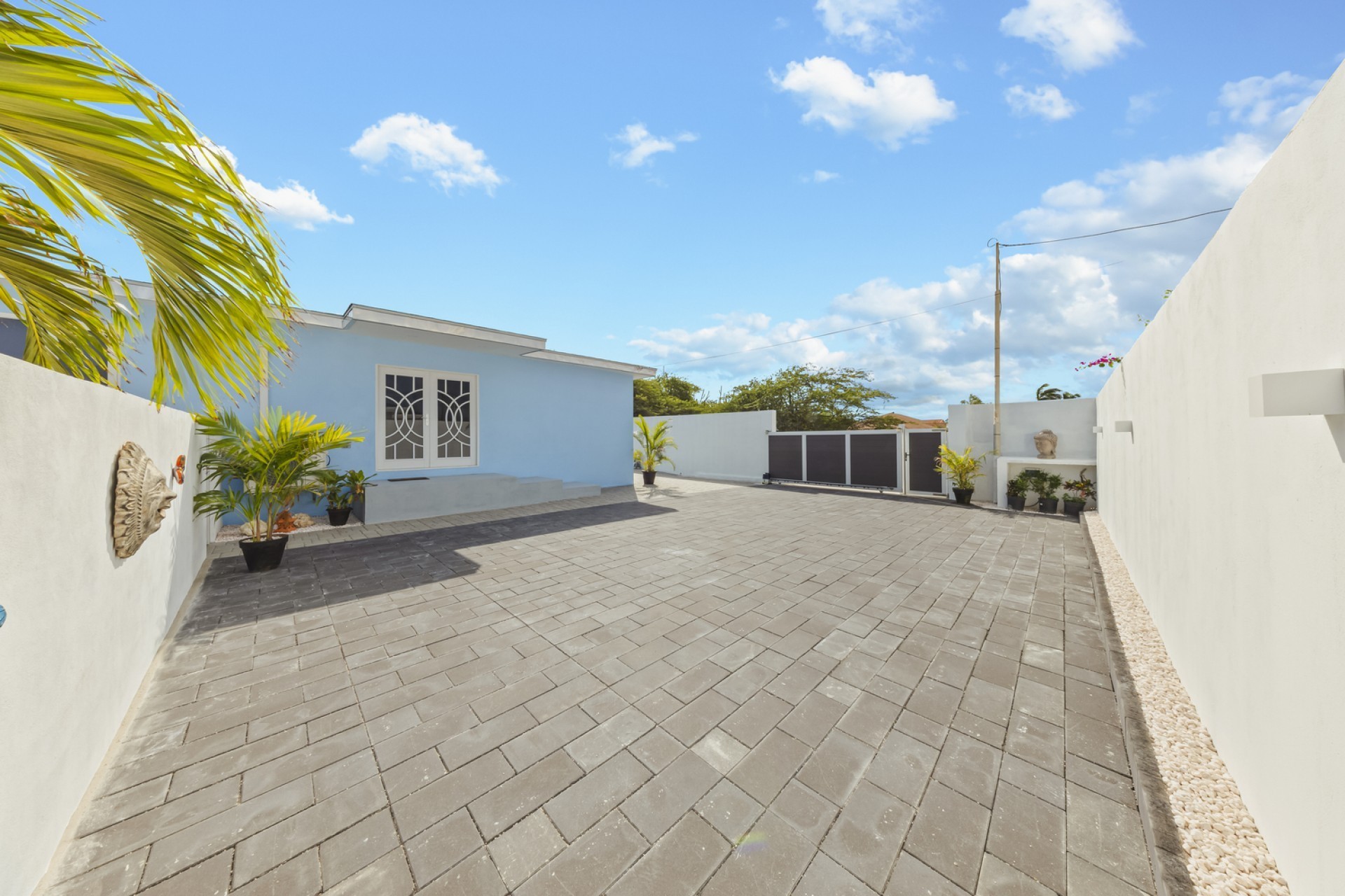 Large paved driveway and gated entrance at Pos Abao 10 F villa in Noord, Aruba.