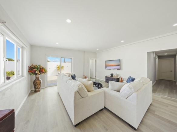 Living room with large seating area and sliding doors leading to the outdoor courtyard at Pos Abao 10 F in Noord, Aruba.