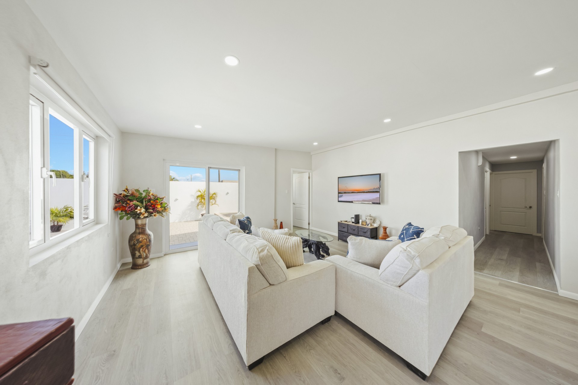 Living room with large seating area and sliding doors leading to the outdoor courtyard at Pos Abao 10 F in Noord, Aruba.
