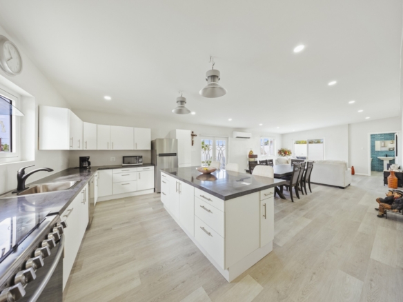 Modern kitchen with central island, white cabinetry, and open layout at Pos Abao 10 F villa in Noord, Aruba.
