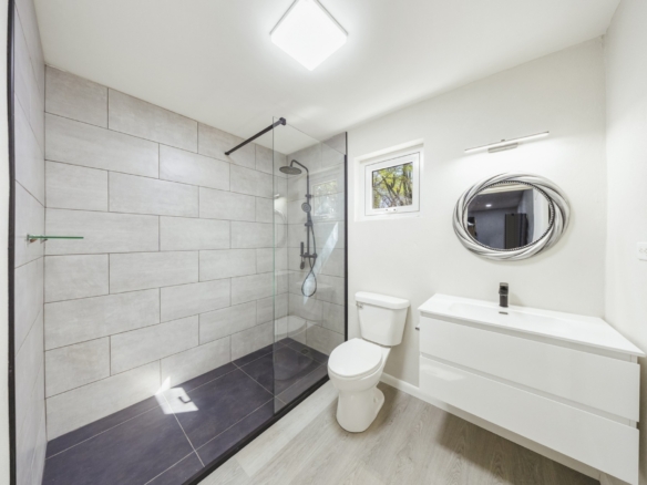 Bathroom with floating vanity, glass shower enclosure, and tiled accent walls at Pos Abao 10 F in Noord, Aruba.