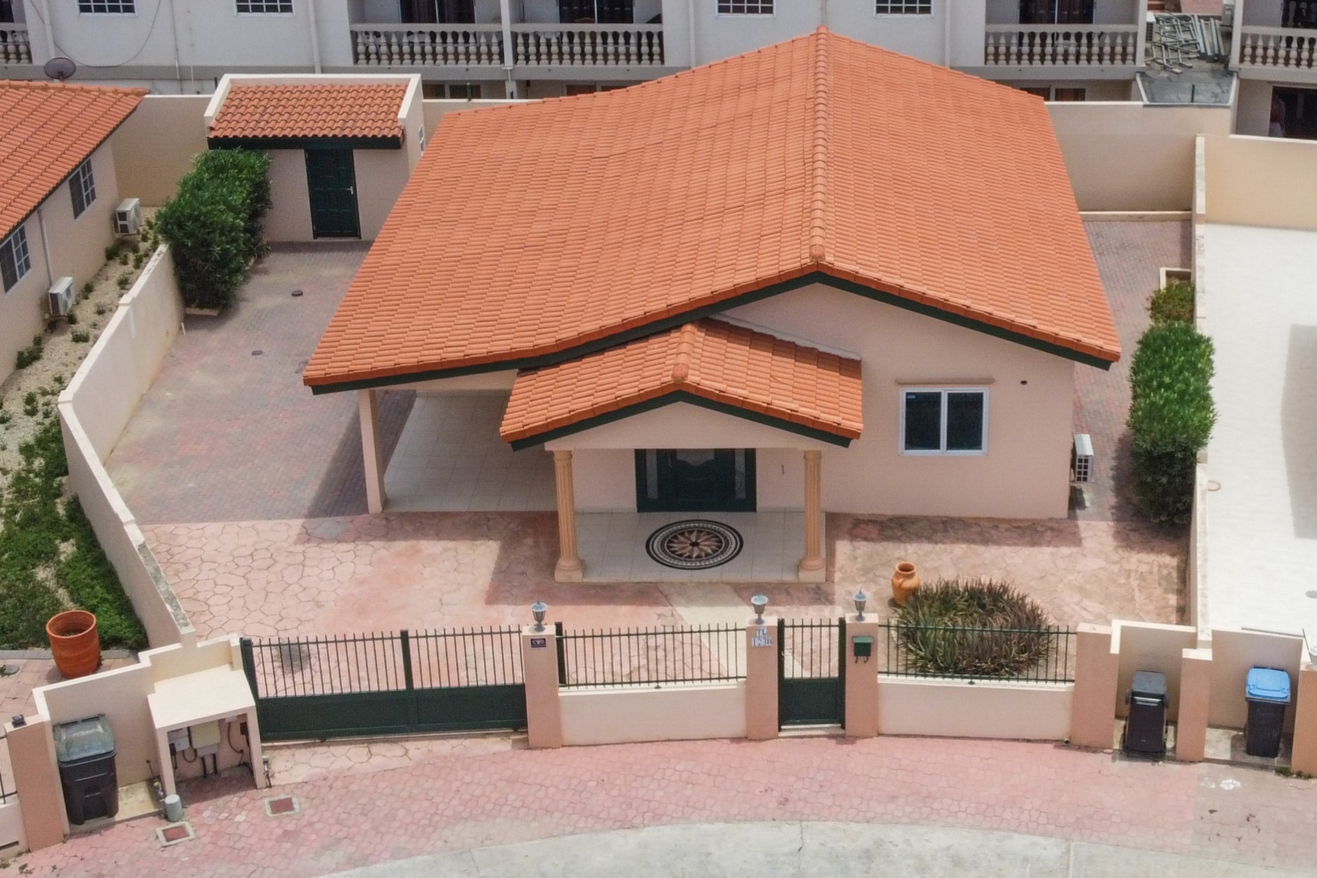 Aerial view of Tanki Leendert 123-B showing the home, driveway, covered parking, and enclosed yard.