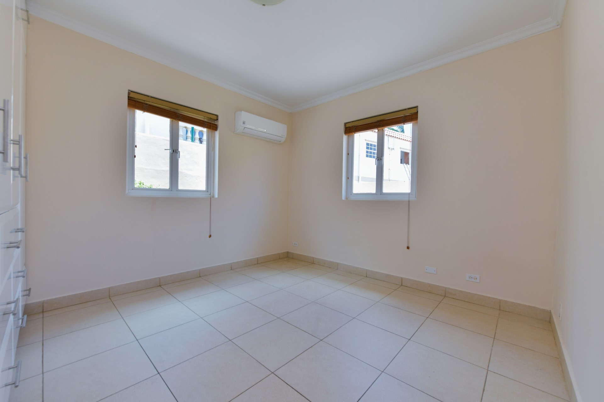 Bedroom with tiled flooring, air conditioning, and natural light in Tanki Leendert 123-B Aruba.