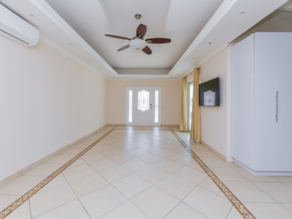 Bright living room with decorative ceiling details, tiled flooring, and natural light in Tanki Leendert Aruba.