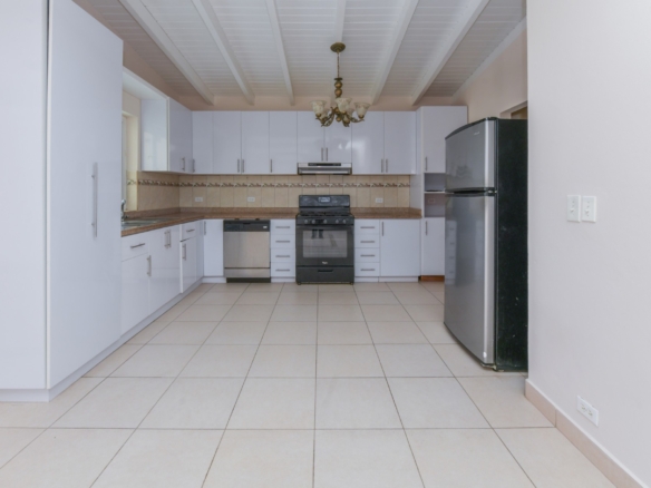 Modern kitchen with white cabinets, granite countertops, stainless steel appliances, and ample storage.