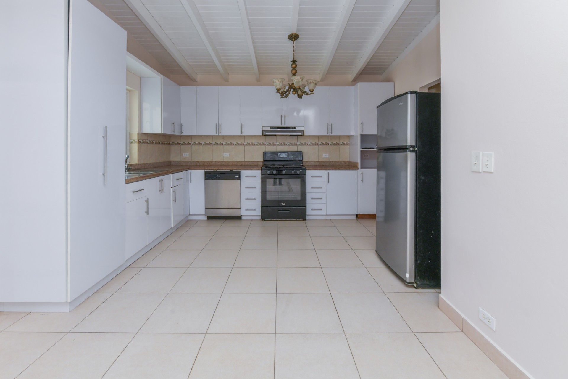 Modern kitchen with white cabinets, granite countertops, stainless steel appliances, and ample storage.