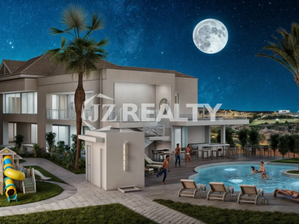 Outdoor swimming pool illuminated at night surrounded by landscape lighting at The Moon Luna Building in Aruba.