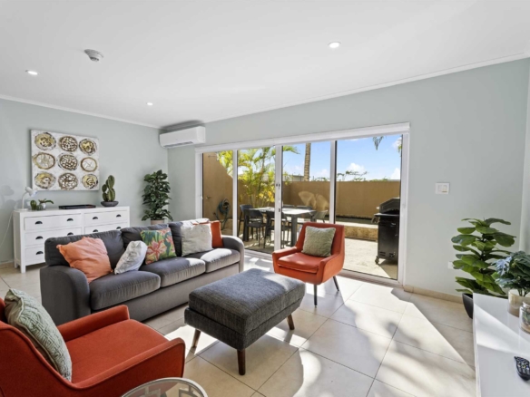 Living room opening onto the private patio at LeVent Townhouse 13, Eagle Beach Aruba