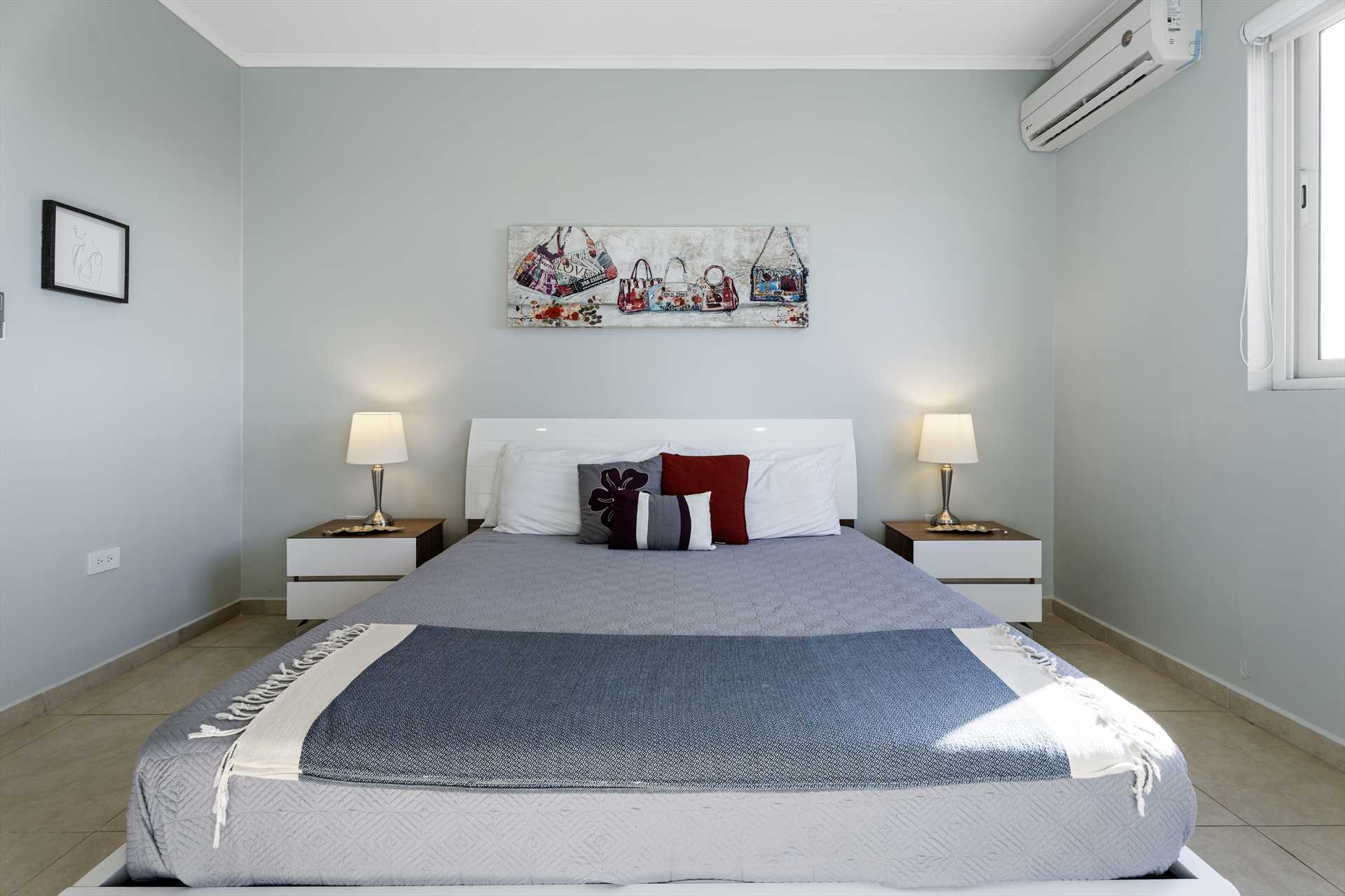 Furnished primary bedroom with king-size bed at LeVent Townhouse 13 in Eagle Beach, Aruba