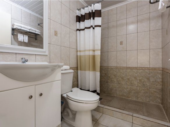 Tiled apartment bathroom with shower at Marquee Apartments in Noord, Aruba.